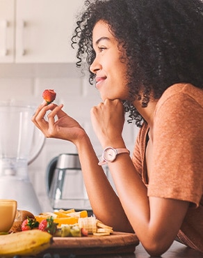 Una mujer haciendo maridaje del café Cappuccino Skinny con frutas