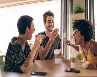 Tres amigos disfrutando de un chocolate caliente Chococino NESCAFÉ® Dolce Gusto®